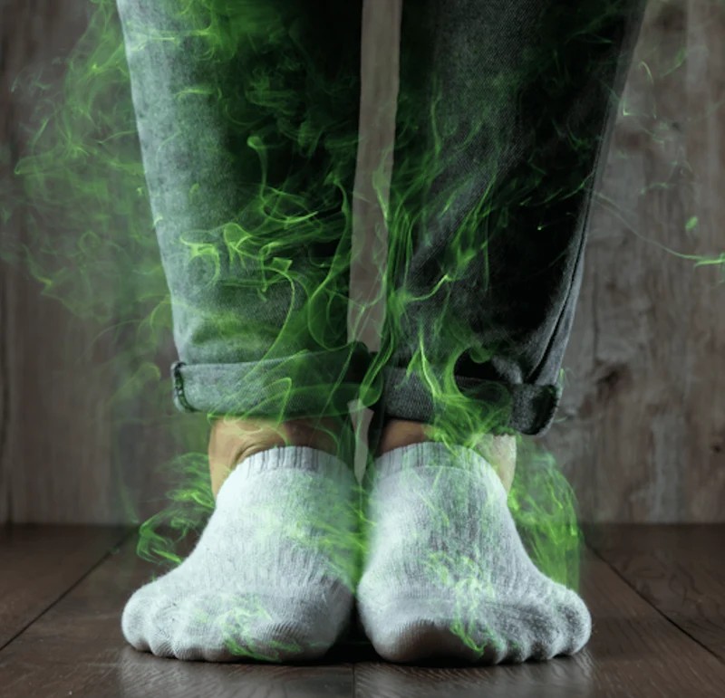 Füße in weißen FUSSLIS Sneaker-Socken mit grünem antibakteriellem Dunst